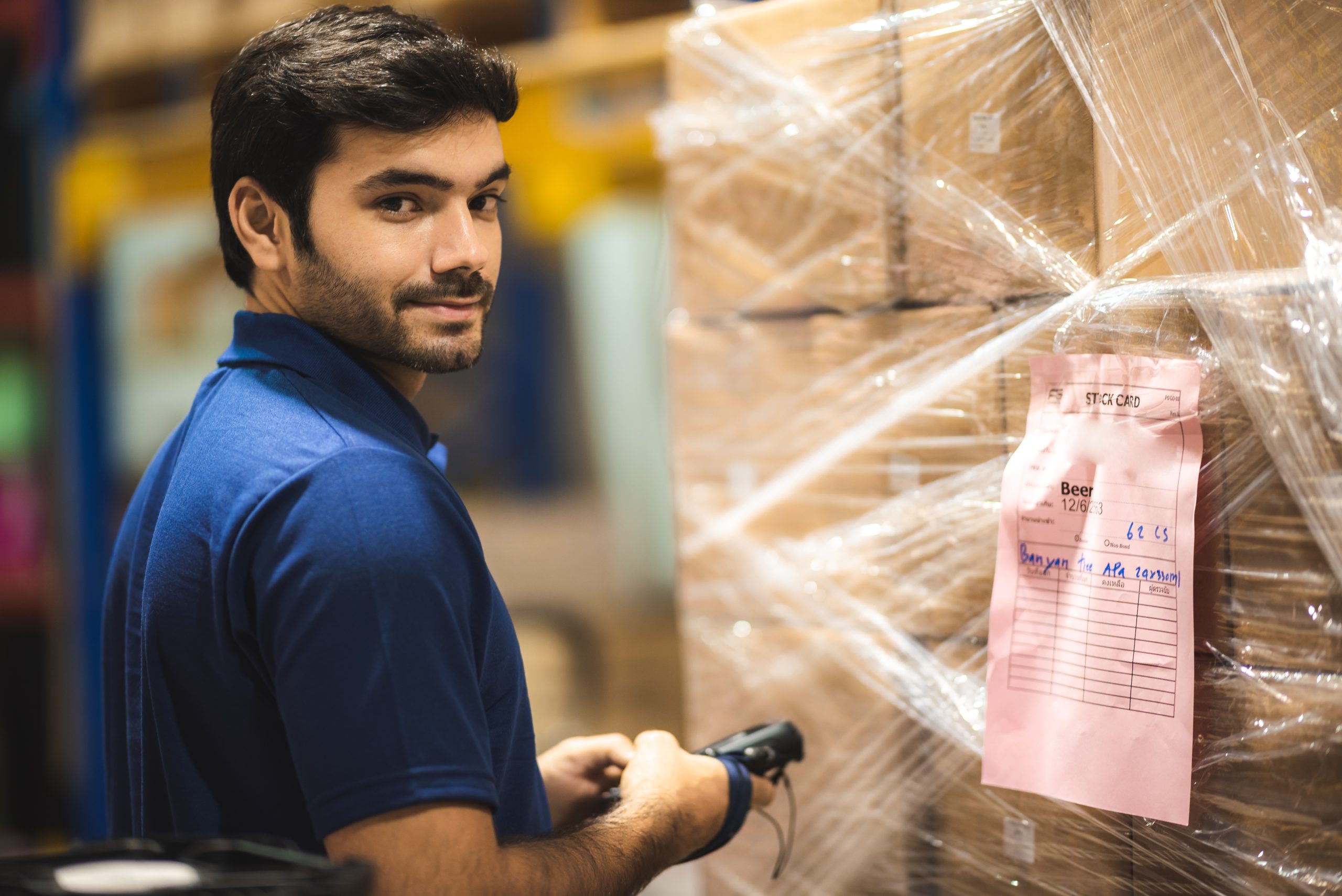 warehouse worker using bar code scanner to analyze newly arrived goods for further placement in storage department, logistic working at warehouse.